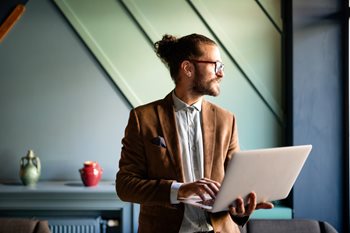 CIO holding laptop wondering how to take to make digital transformation a success post-COVID