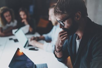 Confused IT leader looking at laptop trying to understand why digital transformation isn't working