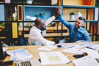 CIO high-fives colleague after implementing their governance, risk and compliance framework